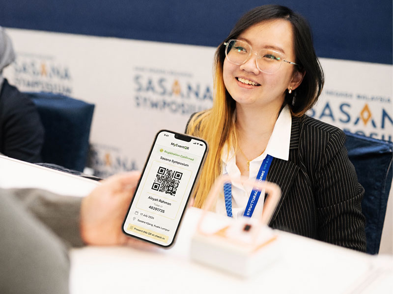 Attendee presenting a MyEventQR registration QR code on her phone at an event check-in counter